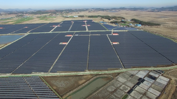 해남 57MW 태양광발전소 전경. 만호염전으로 유명했던 이곳은 4년간의 인허가와 2년간의 설치를 통해 국내 최대의 태양광발전소가 되었다. 앞면에 있는 발전소가 JW솔라파크, 좌측이 JW에너지, 상단이 금오에너지 등 총 57MW 태양광발전소로 해남읍 변전소와 계통이 연계되어 전력을 판매하게 되었다. 주변에 마을과 대단위 농지, 바다가 펼쳐져 있다. [사진=탑선]