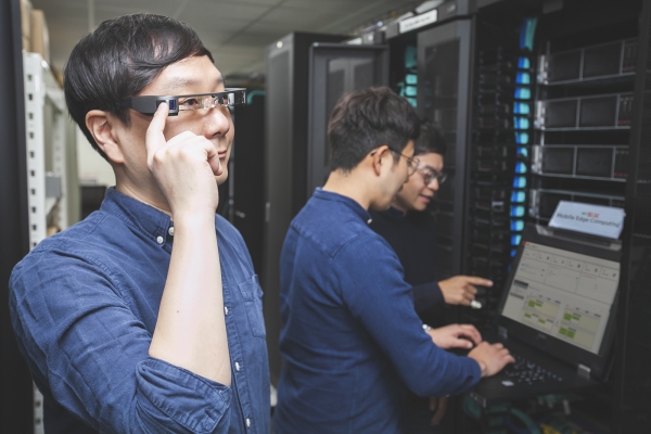 SK텔레콤 연구원이 MEC 플랫폼이 설치된 서버실에서 AR글래스를 쓰고, 산업용 AR서비스를 시험해보고 있다. [사진=SK텔레콤]