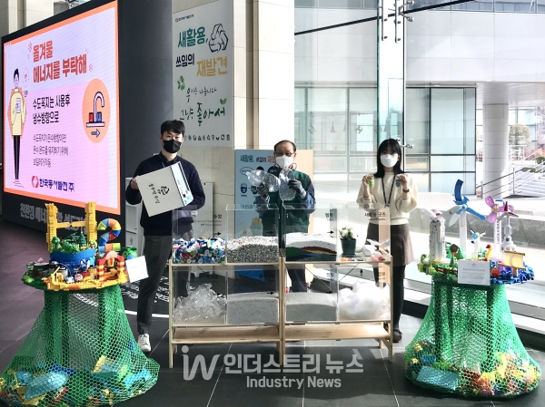 정크아트 전시회에서 관계자들이 새활용 캠페인으로 모아진 플라스틱 병뚜껑이 새활용 굿즈로 재탄생되는 과정을 보여주는 퍼포먼스를 선보이고 있다. [사진=한국동서발전]