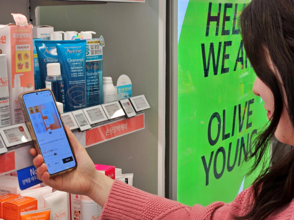 올리브영 매장에서 한 고객이 '전자라벨-NFC 기반 상품 탐색 서비스'를 이용하고 있다./사진=CJ올리브영