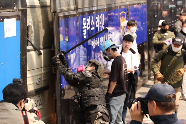 4일 서울 종로구 헌법재판소 인근에서 윤석열 대통령 지지 집회 참가자 중 한 명이 헌재의 윤 대통령 파면 결정에 경찰이 세운 가벽 사이로 보이는 차량을 부수고 있다./사진=연합뉴스