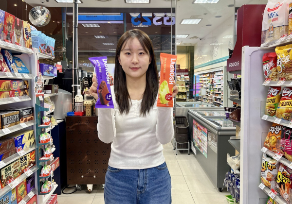 GS25에서 모델이 랩노쉬 저당 프로틴바 2종을 들고 포즈를 취하고 있다./사진=GS25