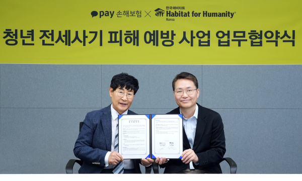 장영근 카카오페이손해보험 대표(오른쪽)와 윤형주 한국해비타트 이사장이 '청년 전세사기 피해 예방 사업’ 업무협약식에서 협약서를 함께 들어보이고 있다/사진 = 카카오페이손해보험