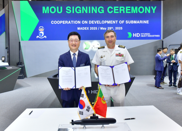 주원호 HD현대중공업 특수선사업대표(왼쪽), 페르난도 피레스(FERNANDO JORGE PIRES) 포르투갈 해군 물자본부장이 부산 벡스코에서 개최된 MADEX 2025 현장에서 업무협약을 체결하고, 협약서를 들어 보이고 있다./사진=HD현대