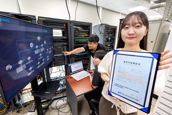 KT와 코위버 직원이 양자키분배 기술 적용 장비를 점검하며 보안 인증서를 소개하고 있다./사진=KT