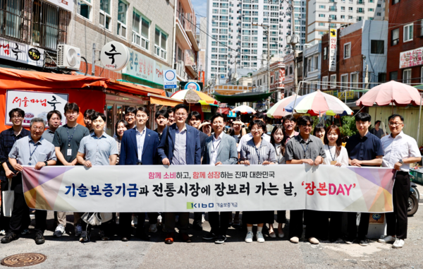 천창호 기보 이사(왼쪽 네번째)를 포함한 기보 임직원들이 부산 진구 범천동 철뚝전통시장에서 '장본DAY' 봉사활동 후 기념촬영을 하고 있다 / 사진= 기술보증기금