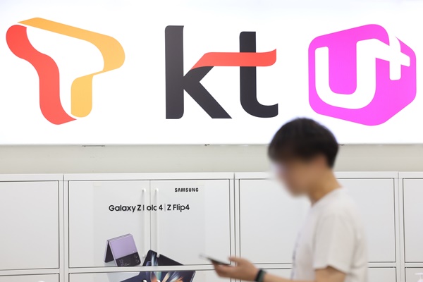 지난 4월 발생한 SK텔레콤 해킹 사건 이후 LG유플러스, KT 등 다른 이동통신사 역시 해커의 공격 대상이 됐다는 의혹이 꾸준히 제기되고 있다. 이통 3사 로고가 선명한 상가를 지나는 한 스마트폰 사용자의 모습./사진=연합뉴스