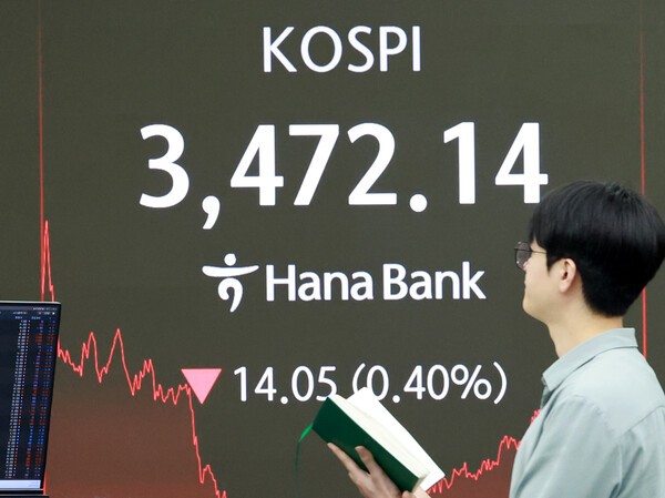 24일 서울 을지로 하나은행 본점 딜링룸에서 한 외환딜러가 증시 현황판 앞을 지나고 있다. 이날 코스피는 전 거래일보다 14.05p(0.40%) 내린 3472.14로 종료했다. 코스닥지수는 전장보다 11.27p(1.29%) 내린 860.94로 마감했다./ 사진 = 연합뉴스 