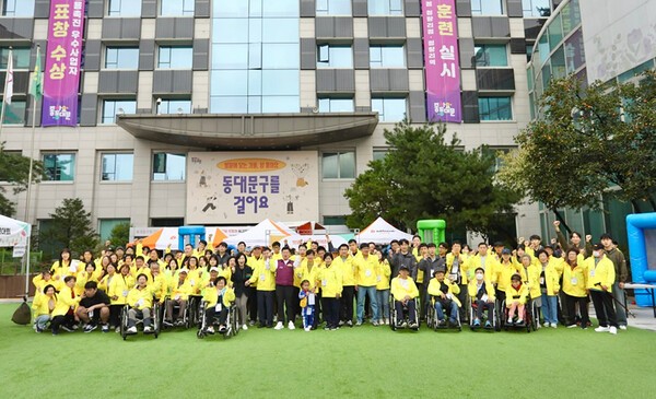 빗썸나눔이 지난 18일 동대문구청 광장에서 개최한 체육대회에 참여한 동대문구 내 장애인과 가족, 비장애인 주민 150여 명, 봉사자 50명이 기념촬영을 하고 있다. / 사진 = 빗썸<br>