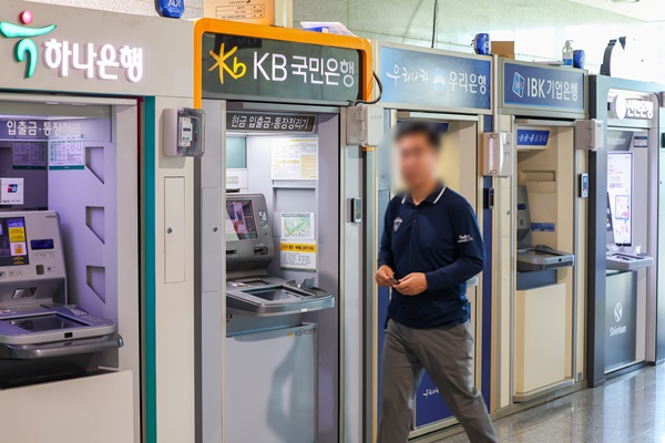 &nbsp;은행들이 설치한 ATM기기 앞을 지나가는 한 이용객 모습. 사진=연합뉴스