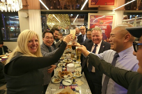 BBQ의 프리미엄 플래그십 매장 ‘BBQ 빌리지 청계광장점’에 미국 네바다 주지사실 산하 경제개발국(GOED) 톰 번스 경제개발국 총괄이사(오른쪽줄 앞에서 세번째) 등 투자사절단이 건배를 하고 있다./사진=BBQ