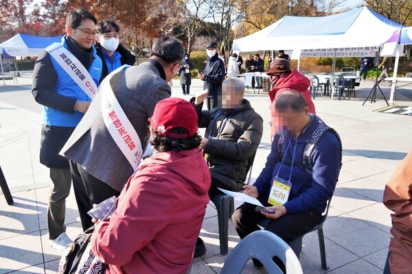 지난 19일 영등포공원 일대에서 우리은행, 서민금융진흥원, 영등포구청 직원들이 지역주민들에게 불법 사금융 피해예방 안내문과 홍보 물품을 나눠주고 있다/ 사진 = 우리은행<br>